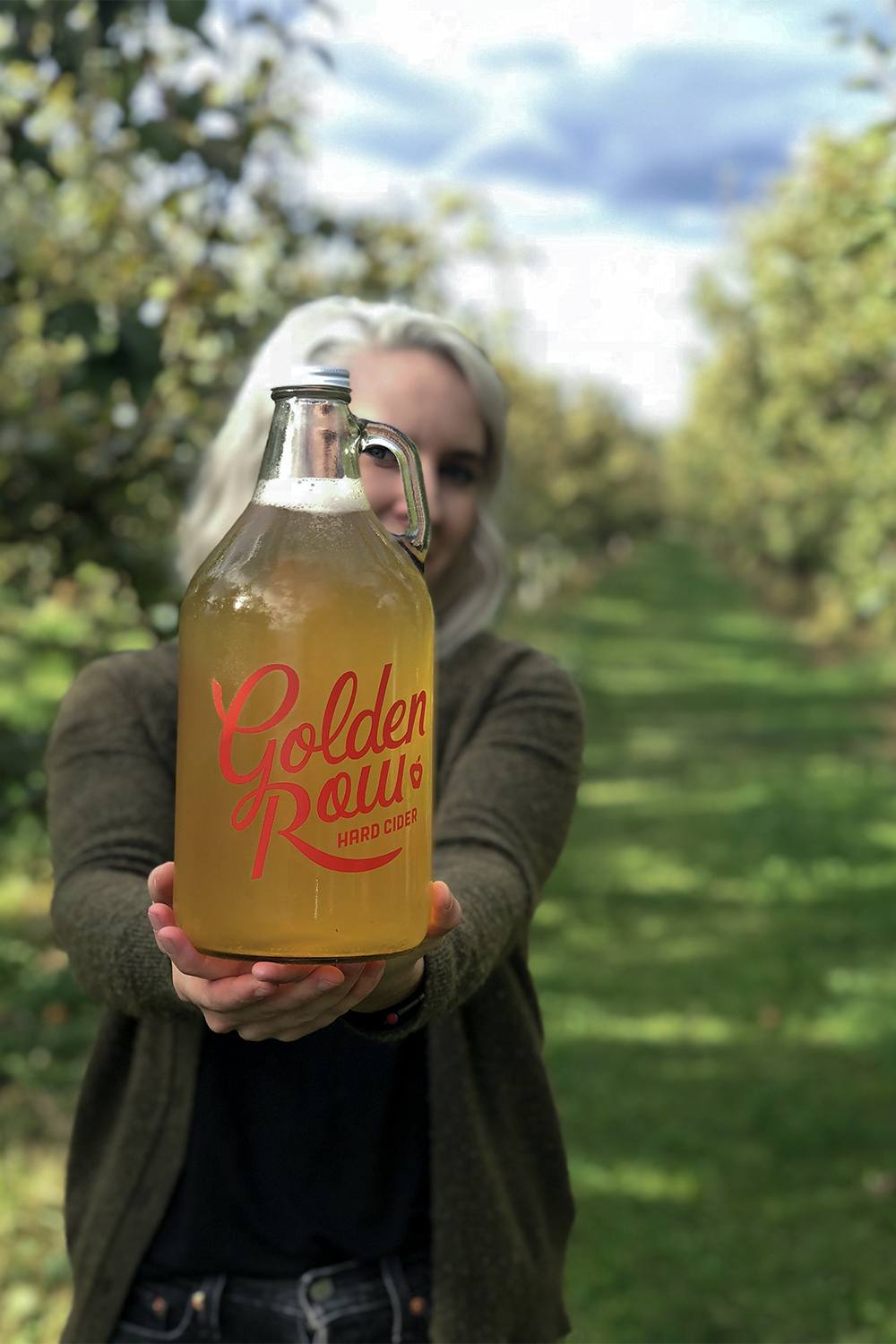 girl holding a growler of cider